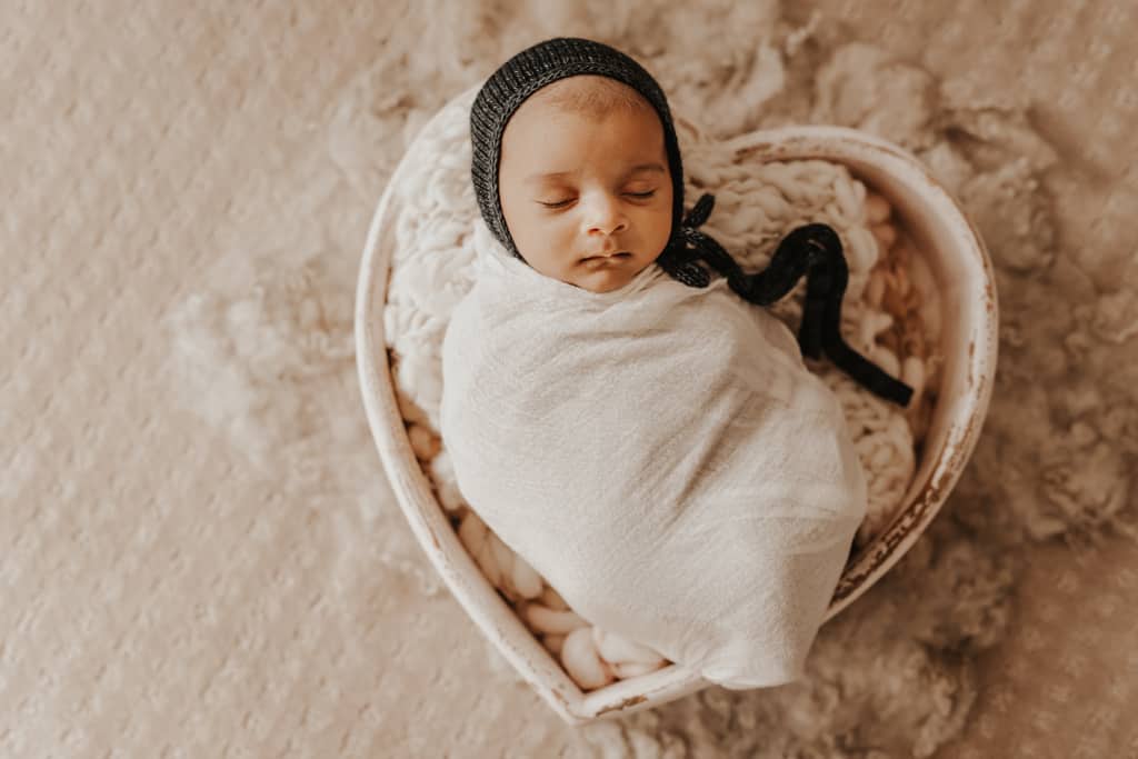 baby girl in round basket newborn photo