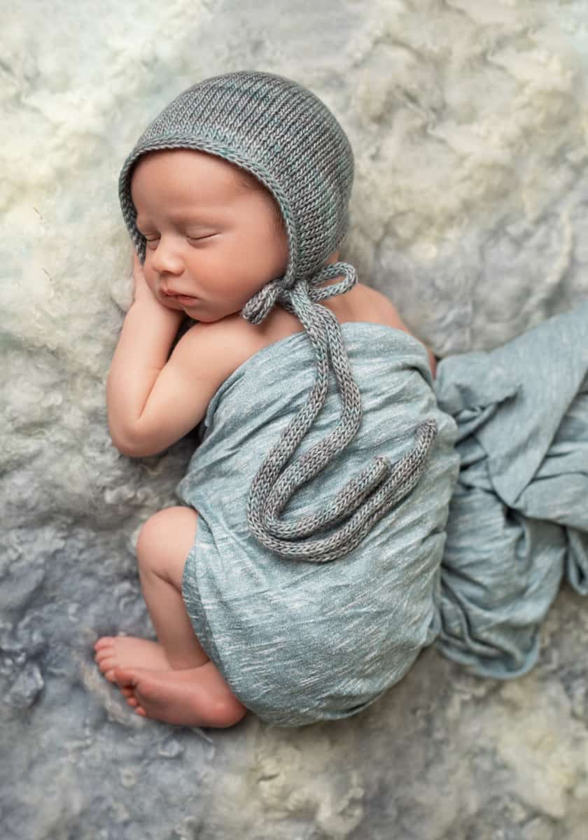 newborn baby boy in blue wrap and bonnet