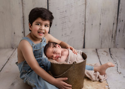 big brother and baby photo with baby in bucket